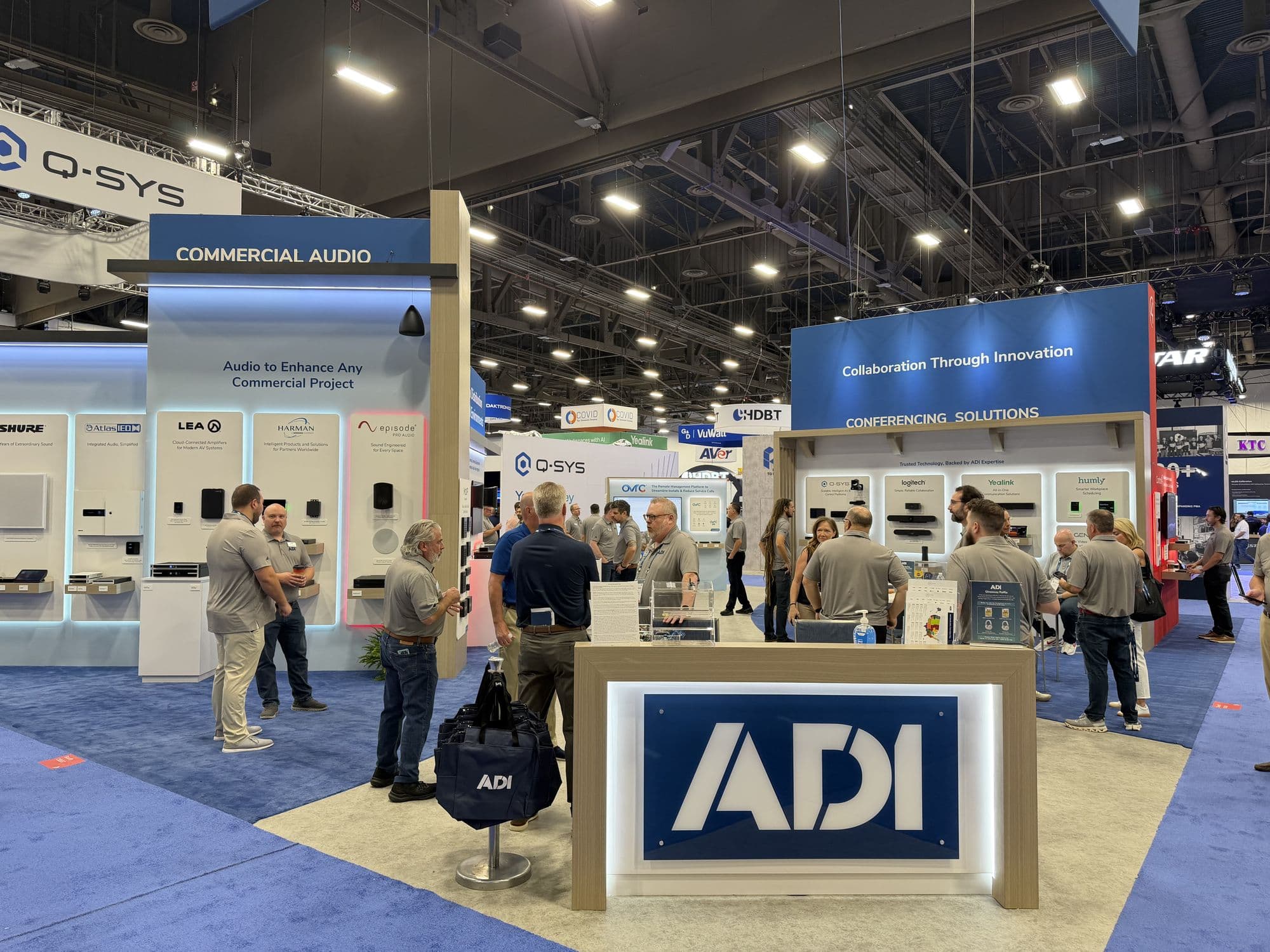 Visitors at the ADI Global booth, with commercial audio and conferencing zones behind the counter