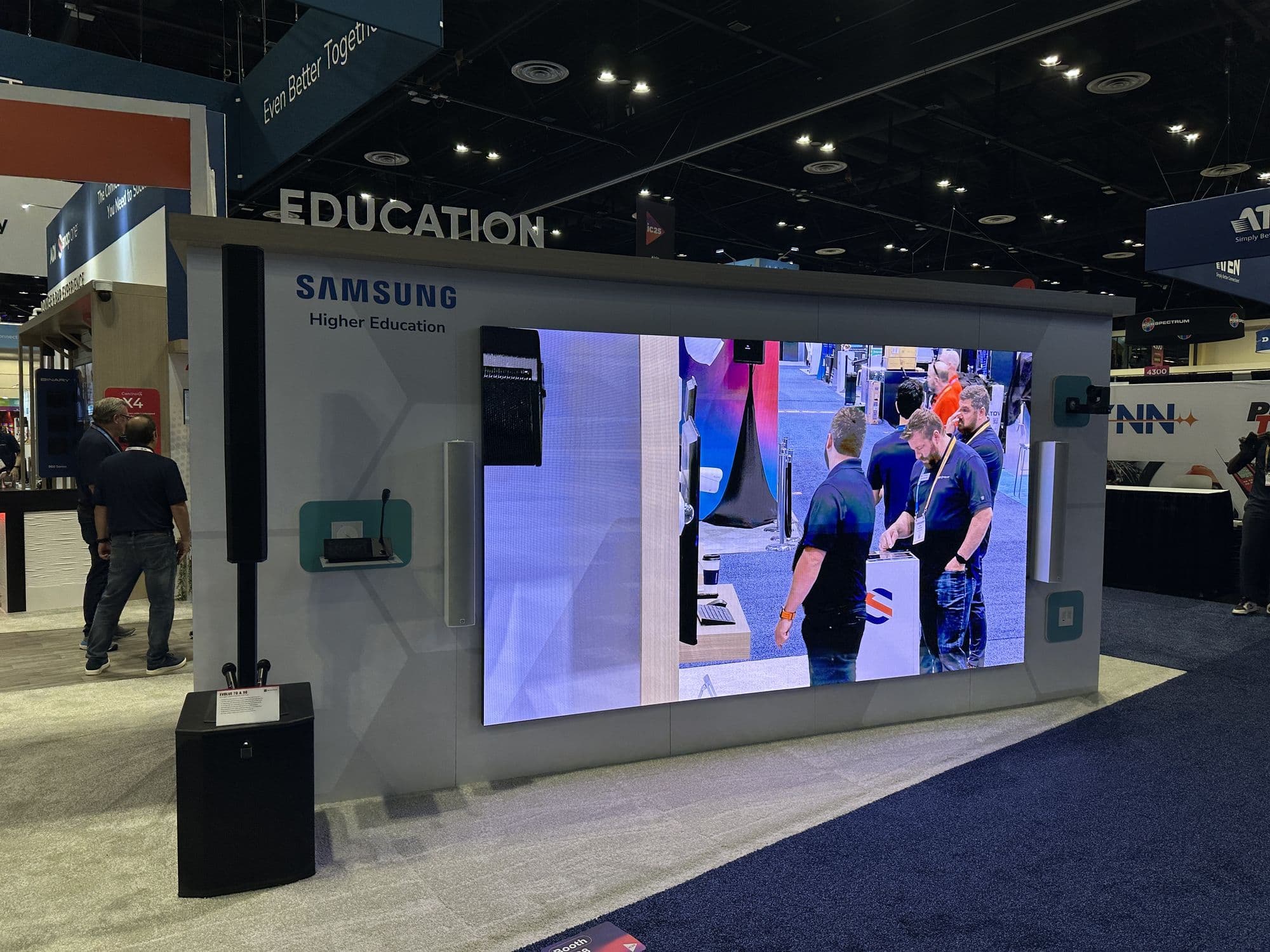 A large LED video wall running live camera footage in the ADI Global booth's education zone
