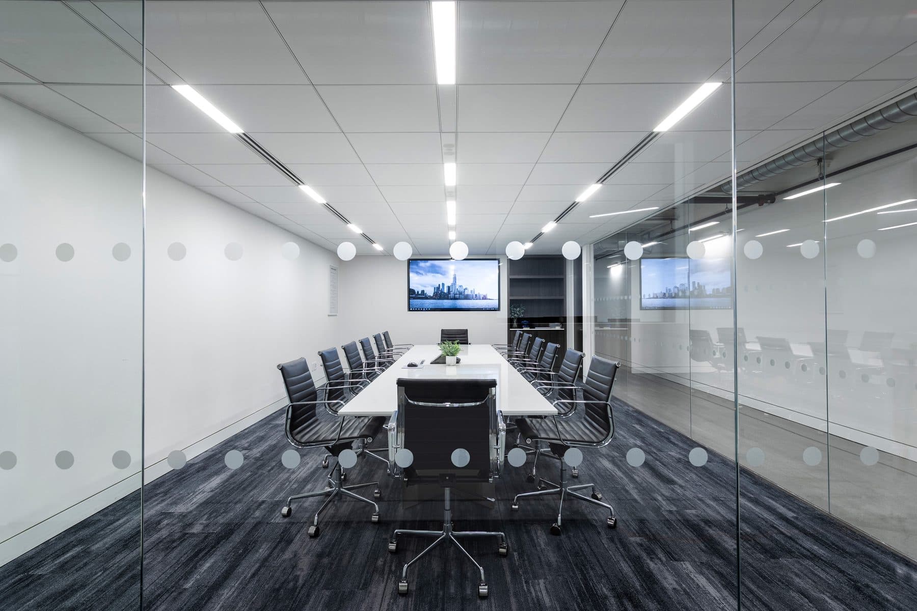 A glass-walled conference room at Andromeda Advantage with a long table and a display at the far end