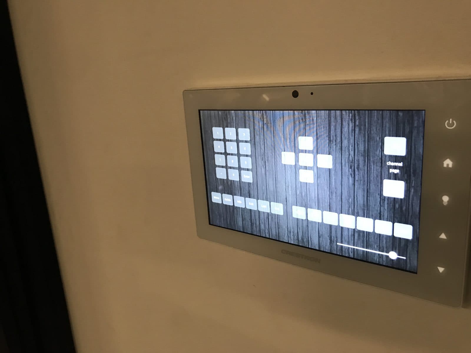 A Crestron touch panel on the wall of a meeting room