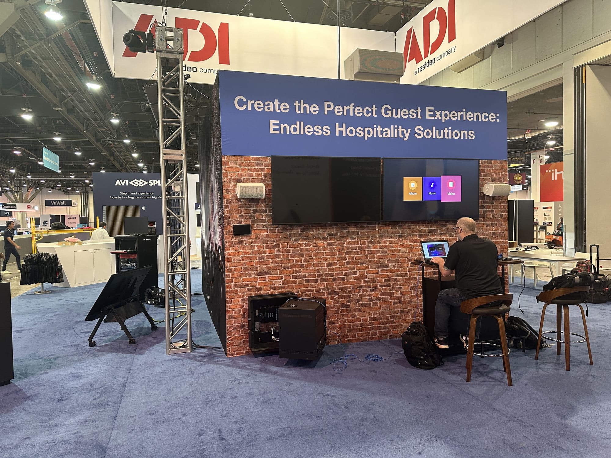 A hospitality demonstration zone with displays on a brick wall, a technician at work